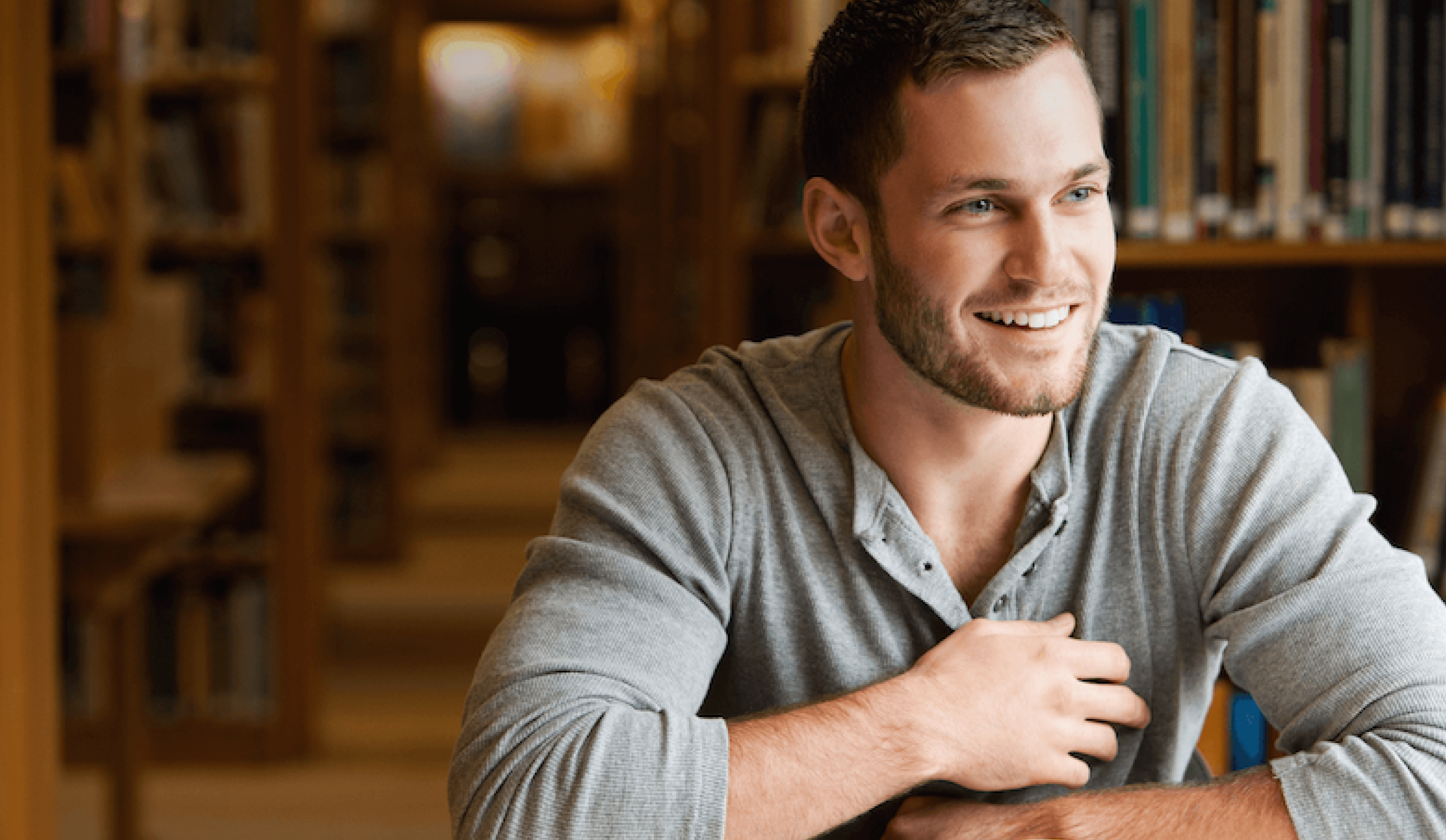 Image of a man in a library smiling