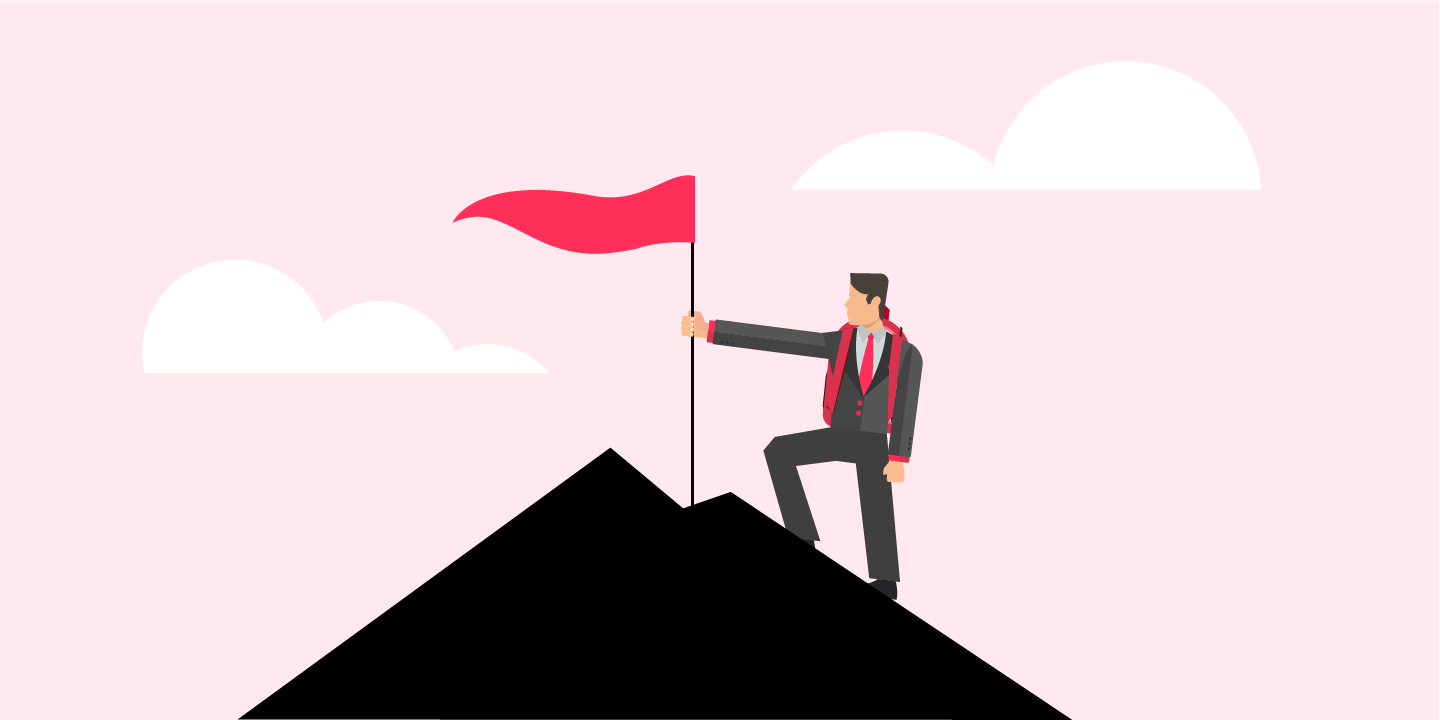 Graduate with flag on top of mountain